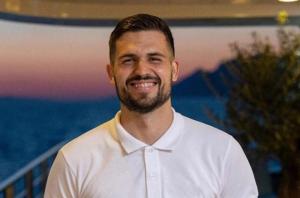 Smiling Crew Member White Polo Yacht Sunset