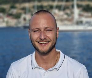 Smiling Crew Member White Polo Sea Background