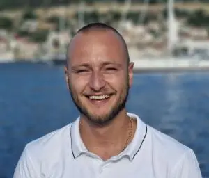 Smiling Crew Member White Polo Sea Background