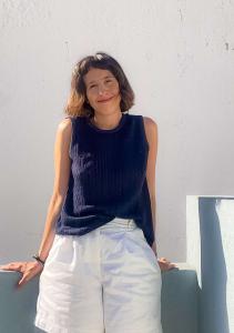 Woman Navy Top White Shorts Leaning Wall