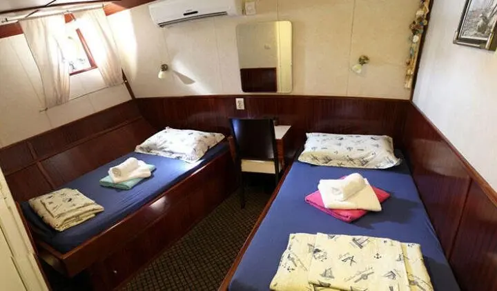 Tajna Mora yacht cabin with twin bunks and an ensuite entry visible