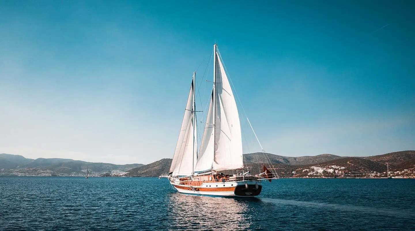 Sailing yacht with tall masts on calm blue sea