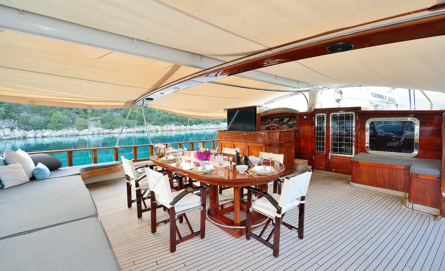 Cobra King gulet on the aft deck with a dining table set and wooden interior