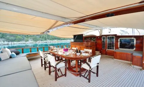 Cobra King gulet on the aft deck with a dining table set and wooden interior