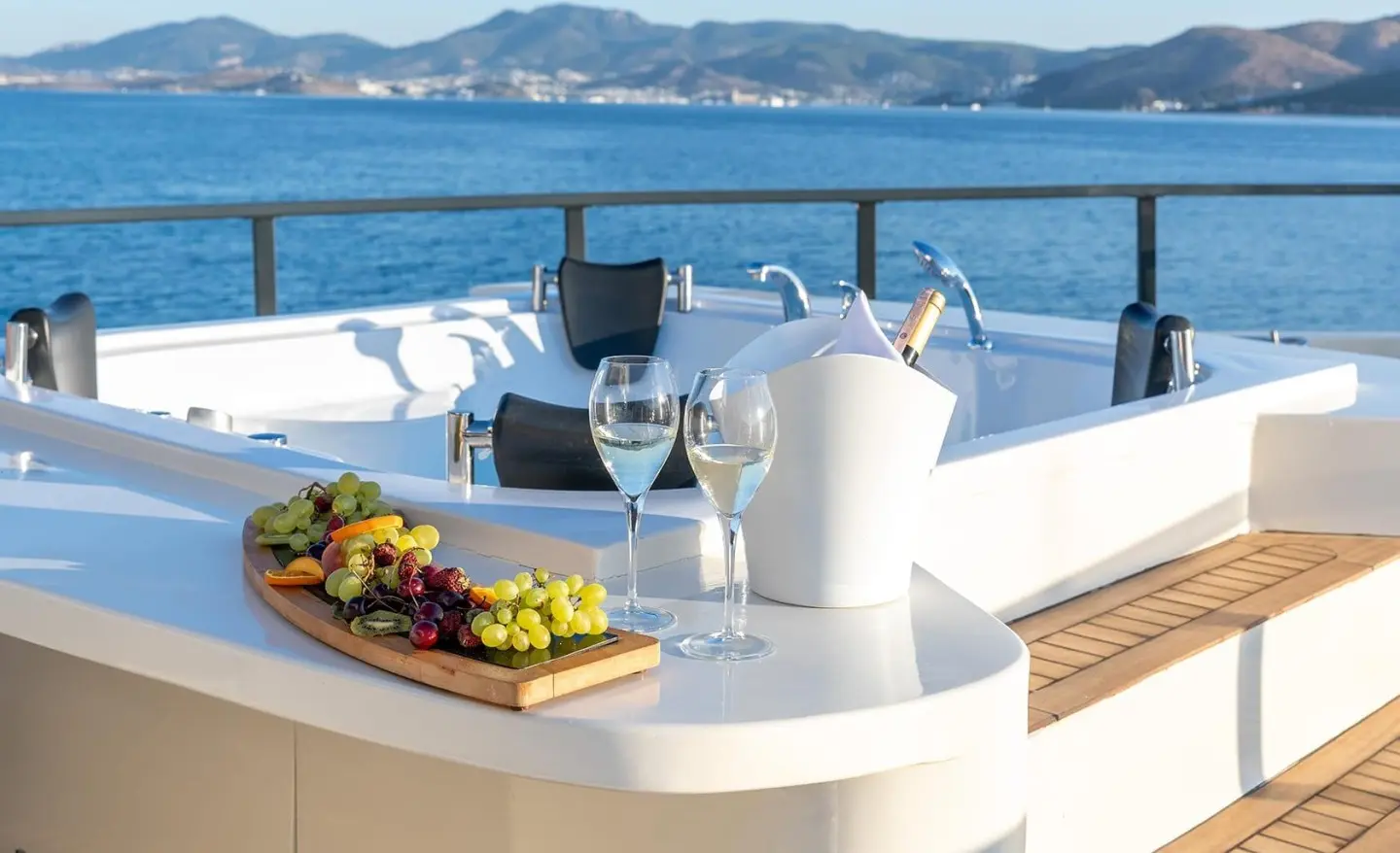 Calm Down motor yacht deck with jacuzzi and beverages on a sunny sea