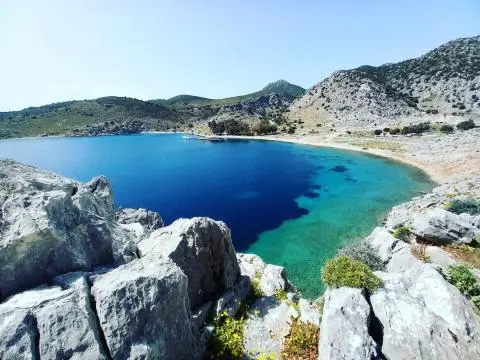 Turquoise bay with rocky cliff shoreline and clear blue water