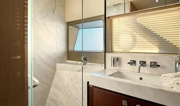 Yacht cabin bathroom with sink, mirror, and wooden cabinetry.