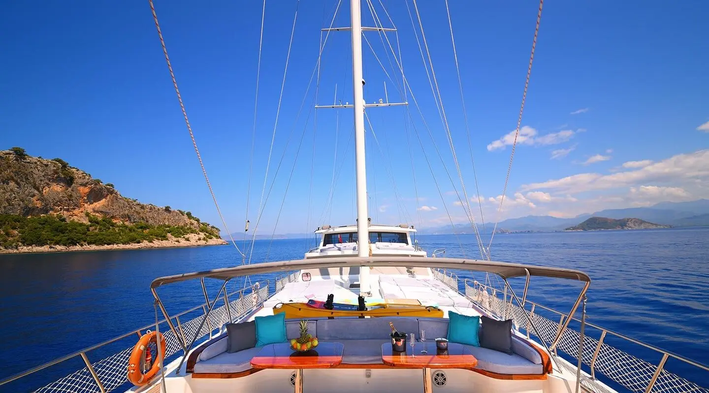View from aft on Maya gulet, deck seating, sails raised, blue sea and sky