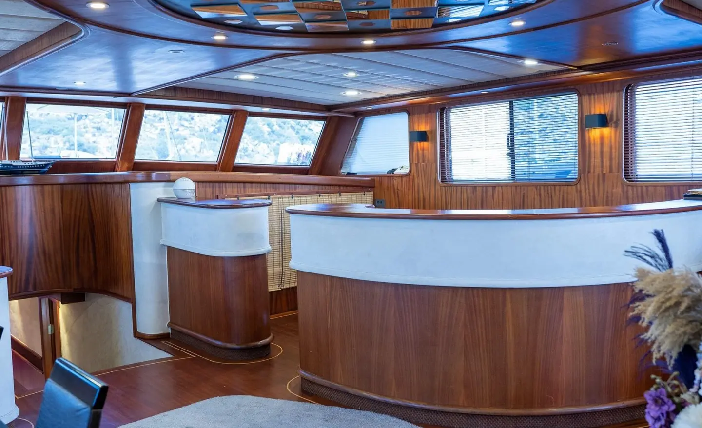 Inside Nevra Queen yacht deck with curved wooden seating and windows