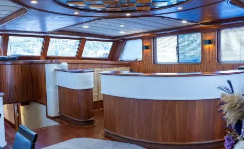 Inside Nevra Queen yacht deck with curved wooden seating and windows