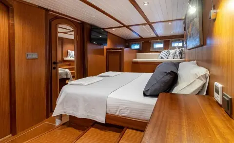 Interior of Bodrum Queen yacht with two single beds, wooden cabin, and pillows