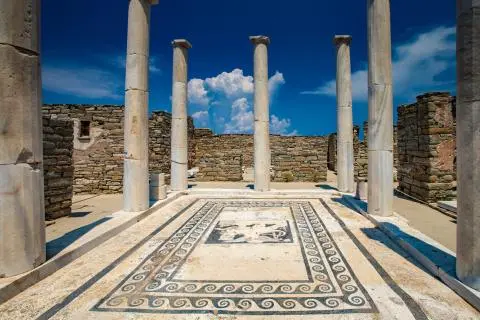 Ancient ruin with marble columns surrounding a black-and-white mosaic courtyard