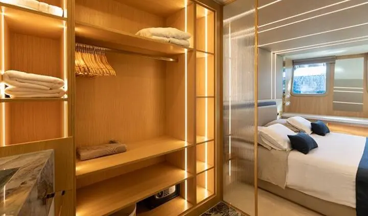Interior cabin closet with wooden shelves and glass doors on Scorpios yacht
