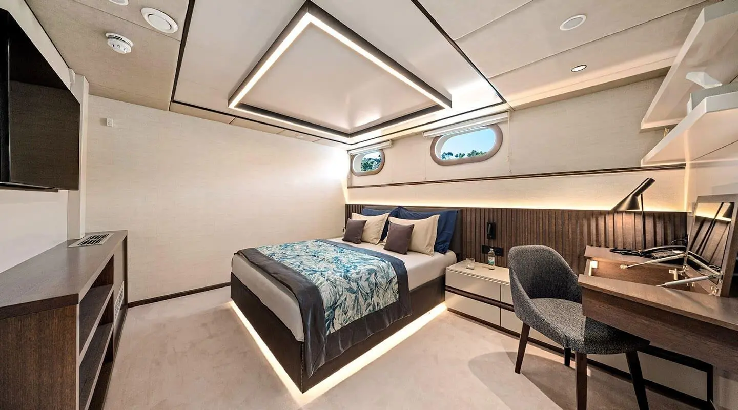 Luxurious yacht bedroom with a large bed, soft lighting, and modern furnishings