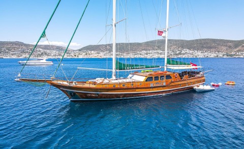 Luxurious wooden gulet yacht Lady Christa anchored on calm blue sea with deck seating and life-saving gear visible