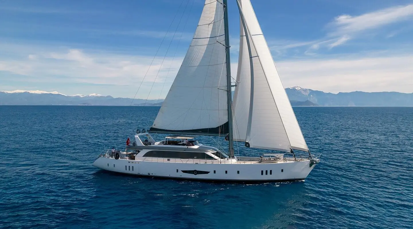 Sailing yacht Long Island with white sails on blue sea at sunset