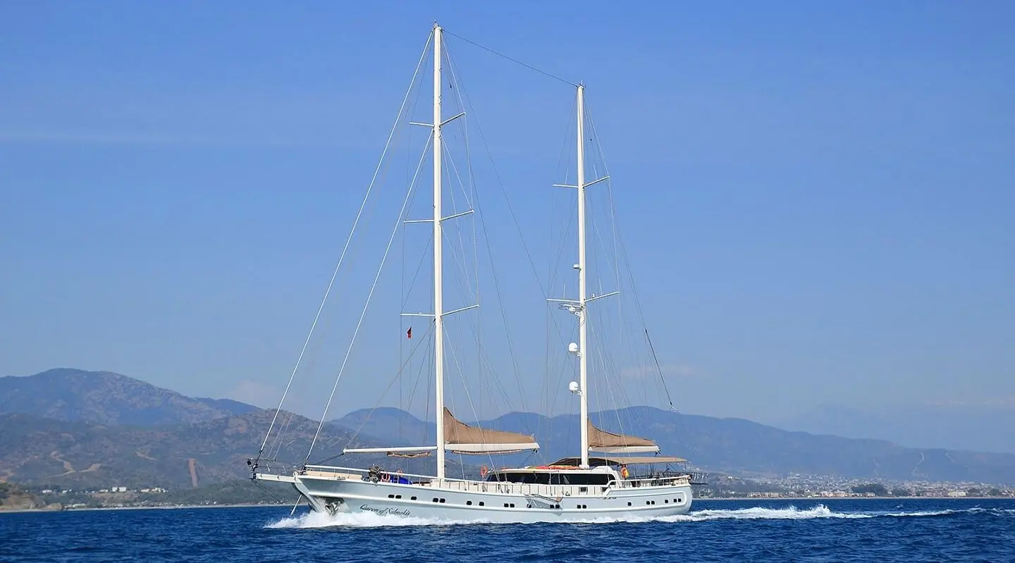 Queen Of Salmakis yacht anchored on calm sea at sunset with sails lowered