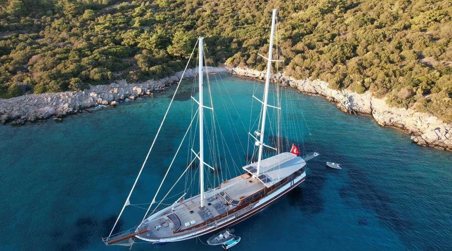 Aerial view of Arif Kaptan A yacht anchored near rocky shore at sunset