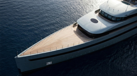 Bow of a luxury yacht with teak deck and white superstructure on open sea