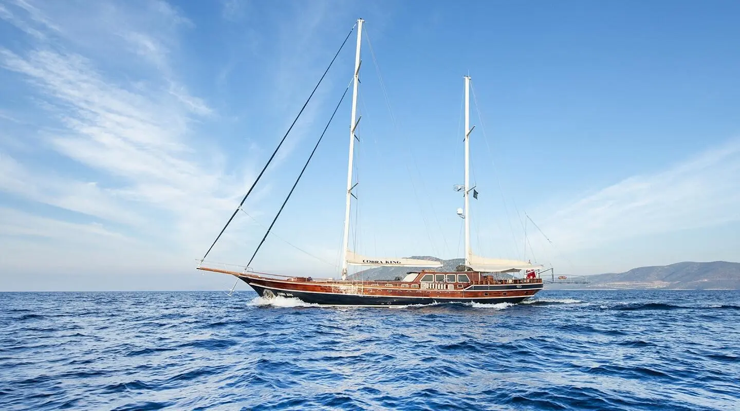 Cobra King luxury yacht with two masts anchors on calm blue sea under clear sky