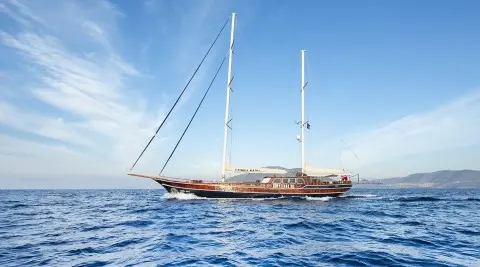 Cobra King luxury yacht with two masts anchors on calm blue sea under clear sky