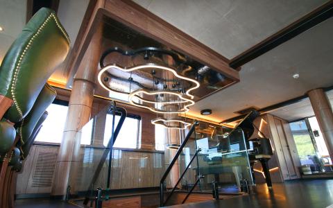 Interior lounge aboard the yacht with wooden columns, glass railing and modern lighting