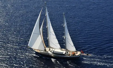 Dolce Mare luxury gulet sailing at sunset with white sails on blue sea