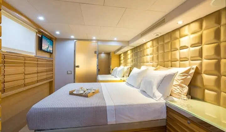Master cabin with king bed, white linens, ensuite bath, warm lighting