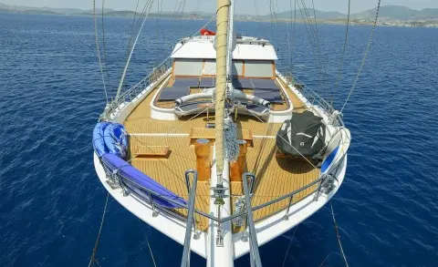 View of the yacht Bella Mare from the bow with sunken deck seating and blue sea