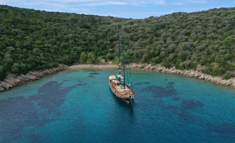 Wooden sailing yacht Ros Mare anchored in turquoise bay