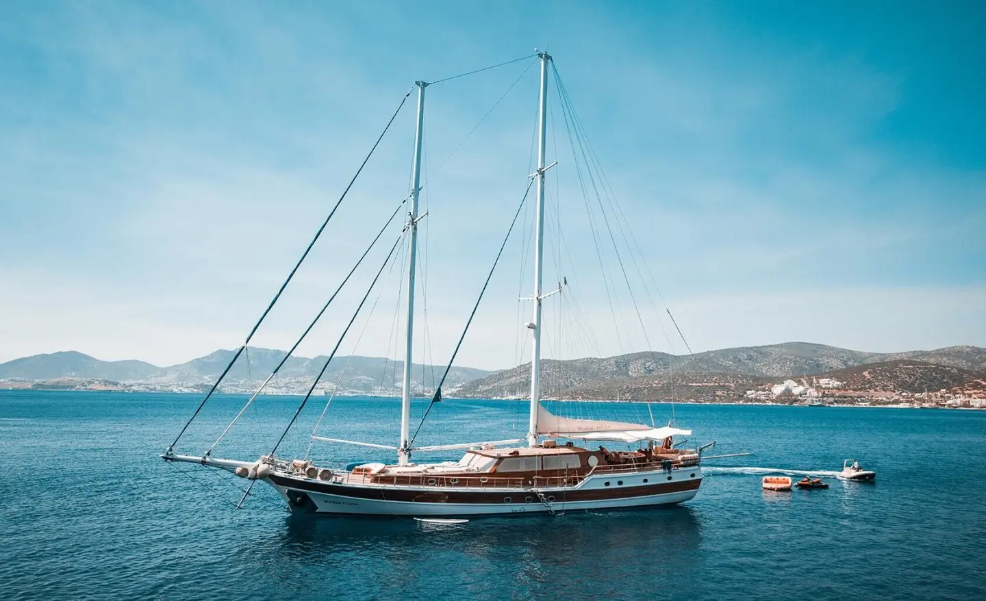 Sailing yacht Wicked Felina anchored in calm blue sea at sunset harbor