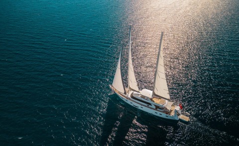Sailing yacht with three masts on open sea under sunlight