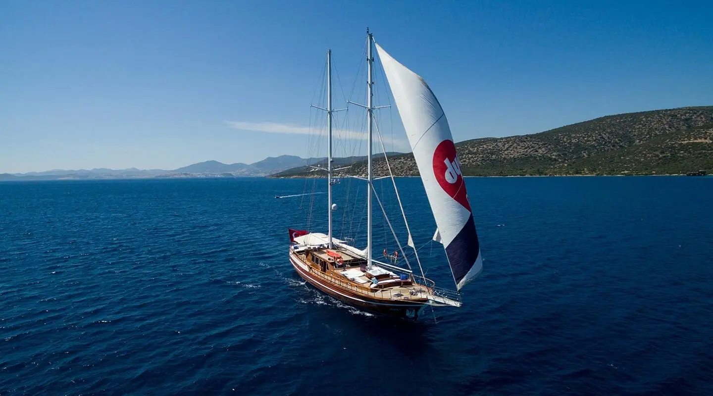 Grace 1 yacht sailing in blue sea with sails unfurled near coastline