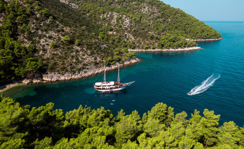 Cesarica 41m yacht anchored in a turquoise bay surrounded by trees
