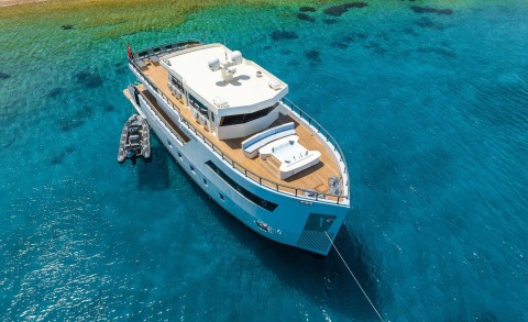 Calm Down yacht on the open sea, upper deck seating area and jacuzzi visible