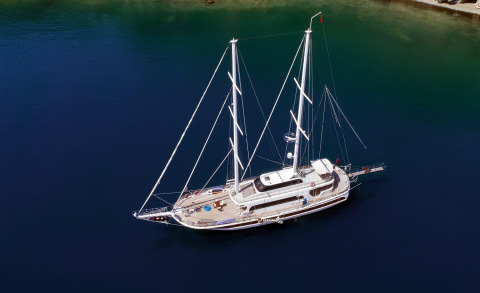 Kayhan 4 sailing yacht anchored in deep blue water with twin masts and teak deck