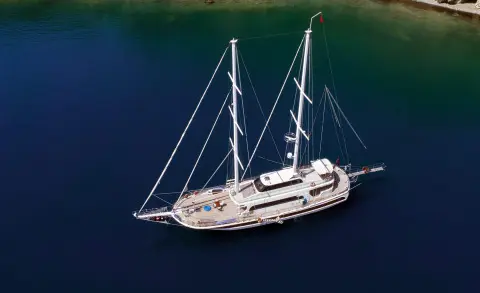 Kayhan 4 yacht anchored on calm blue sea at sunset with sails down
