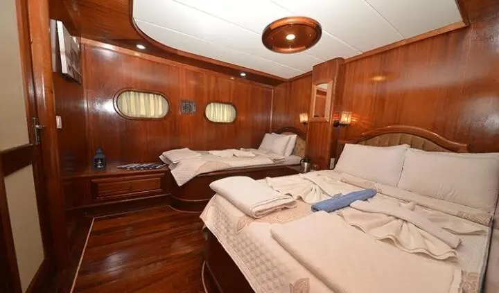 Cozy cabin interior with two single beds, wood paneling, and tidy linens