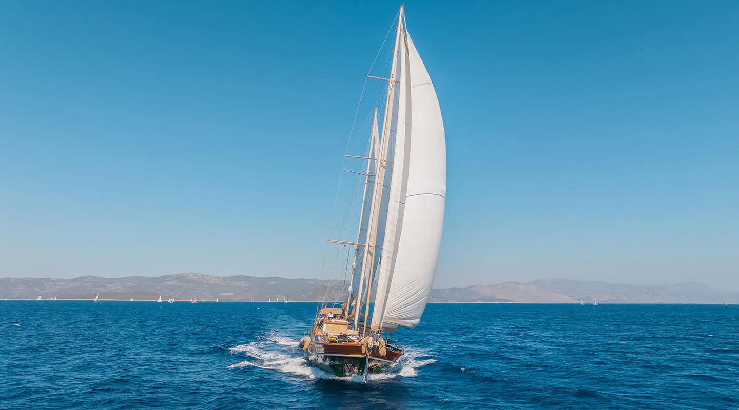 La Bella Vita yacht with a white sailboat on calm blue sea at sunset