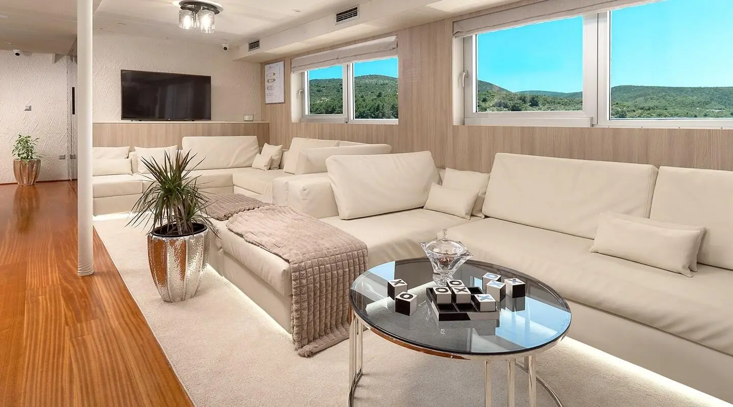 Cristal yacht salon: bright seating area with beige sofas, glass coffee table