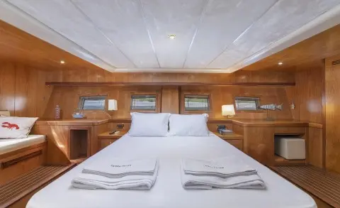 Interior of a luxury yacht galley dining area with neatly set table and wood paneling