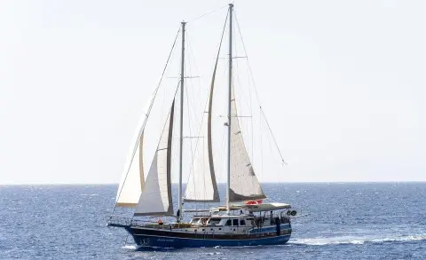 Gozdem The One yacht sailing with tall masts on calm blue sea at sunset