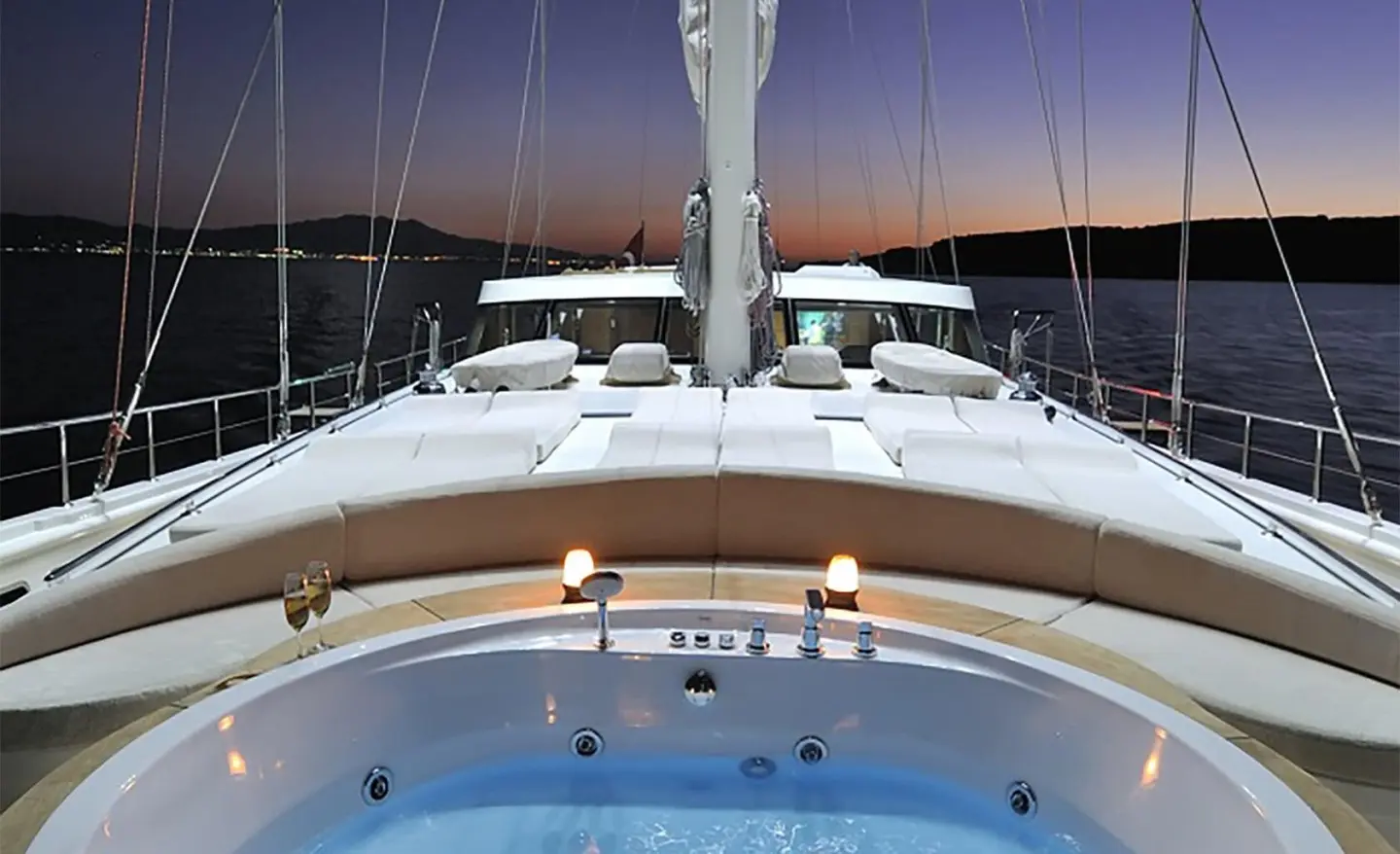 Dolce Mare yacht deck at sunset with blue pool and white seating