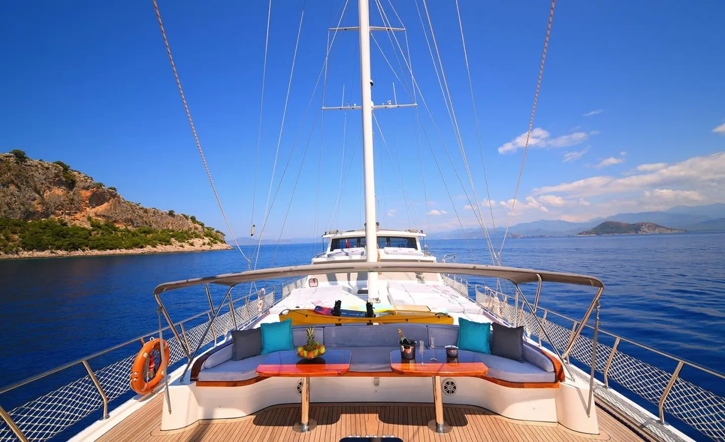 Maya luxury gulet yacht deck view at sunset with seating and sails
