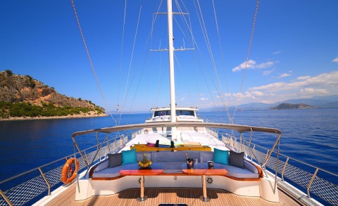 View from the deck with cushioned seating area and sails on a yacht at sea