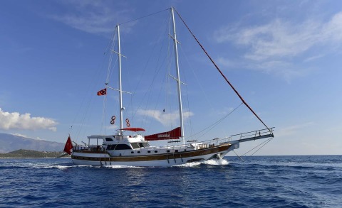 Blu Dream yacht sailing in open sea with two masts and people on deck.