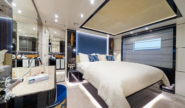 Happy Me cabin interior with plush bed, blue headboard, and mirrored accents