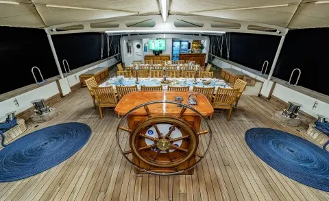 Tersane 8 yacht deck scene with steering wheel, seating, and sunset-lit horizon