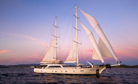 Alessandro I luxury 40m sailing yacht under pink twilight sky at sea
