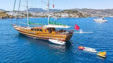 Lady Christa luxury gulet with wooden deck anchored in blue calm sea at sunset